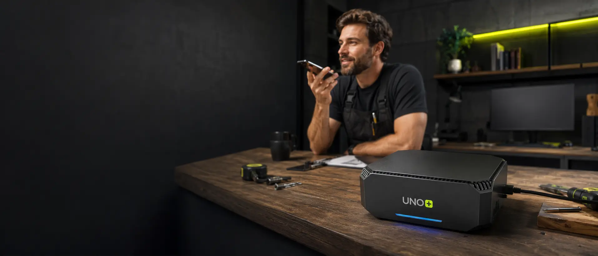 Profesional en su taller hablando con UNO desde el móvil junto al mini PC instalado en su negocio
